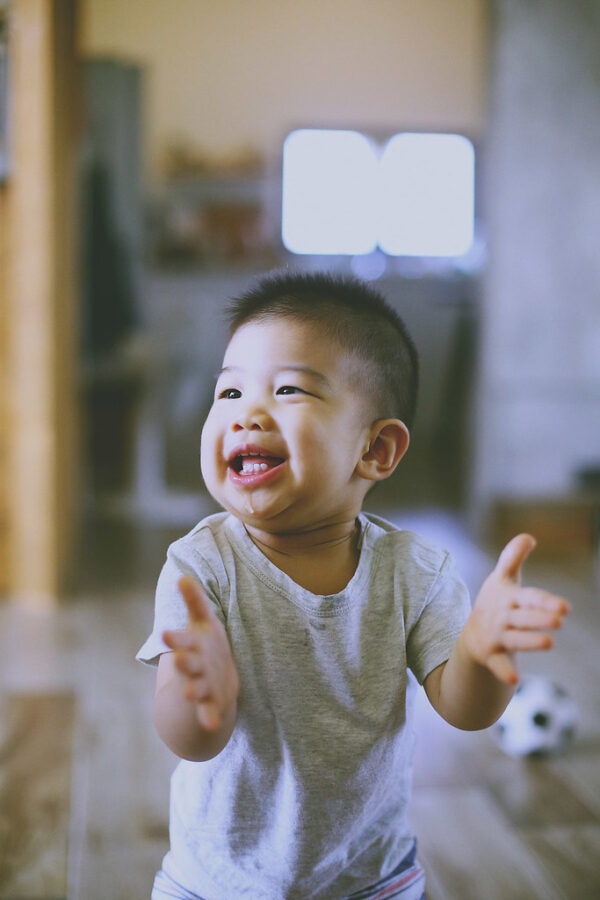 台北親子寫真，小男孩在家裡開心鼓掌，笑容天真自然